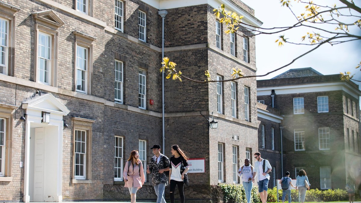 大學生在英國磚砌校舍前的校園步道上行走